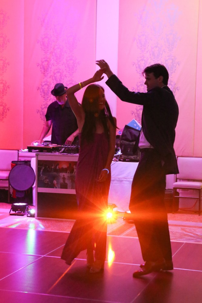 A couple dancing while Goyo works the decks behind them